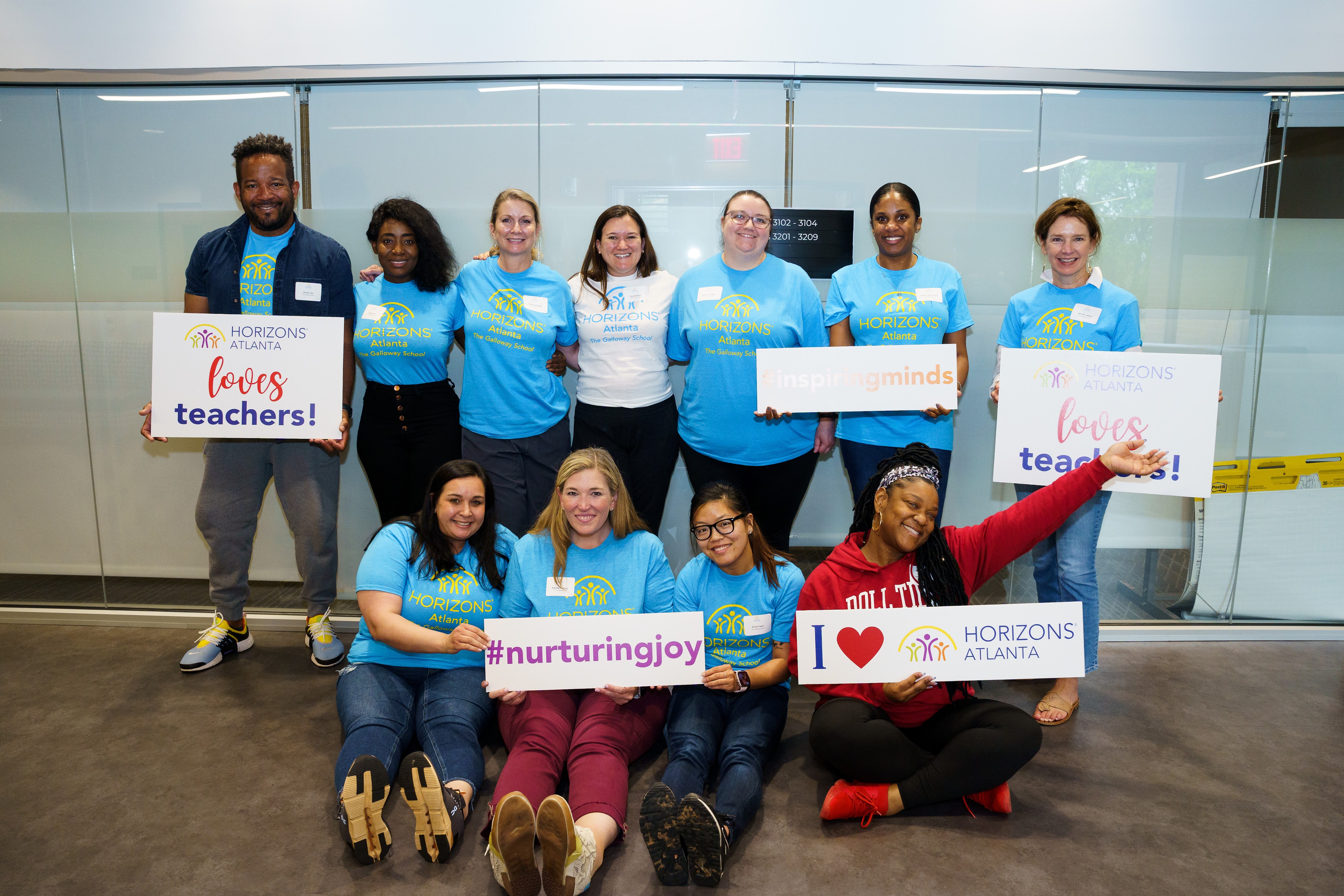 The Galloway staff at Horizons Atlanta posing with event signs and smiling